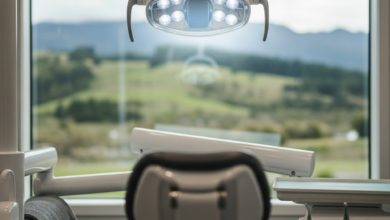 A serene and comforting view from a dental chair, looking up at a modern, soft-glowing dental light. Through a large window in the background, an extremely blurred, peaceful natural landscape hinting at New Zealand's scenery is visible. The clean environment and calming light emphasize relaxation and anxiety relief.