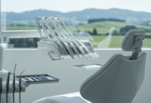 A pristine, modern dental chair in a bright, clean clinic. On a nearby tray, gleaming sterile dental instruments are neatly arranged. Through a softly blurred window in the background, a serene New Zealand landscape with green rolling hills and a clear sky is visible, conveying a sense of calm and quality care.