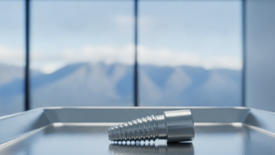 Close-up of a detailed titanium dental implant and abutment on a sterile surface in a modern dental clinic, with a blurred New Zealand landscape visible in the background.