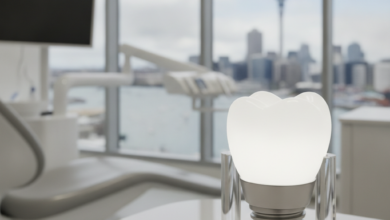 A photorealistic image of a sleek, modern dental clinic interior. In the foreground, there's an abstract, gleaming white dental implant or tooth model. Through a blurred window in the background, the iconic Auckland city skyline and harbor are visible. The scene is bright, clean, and professionally lit.