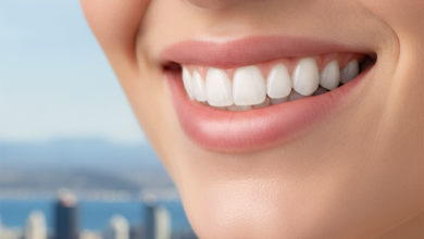 Close-up of a person's bright, confident smile with perfectly white, healthy teeth. The background is softly blurred, subtly revealing elements of the Wellington cityscape.